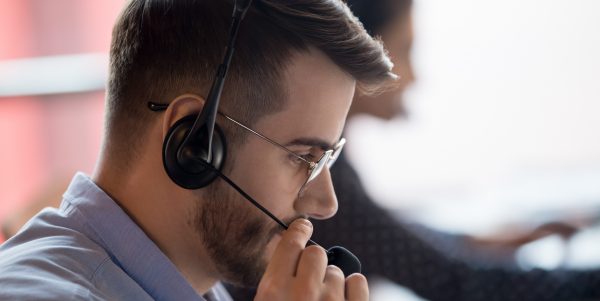 Close up call center worker side view face touch mic chatting with client use microphone give support help online, telemarketing occupation selling distantly services and products to customers concept