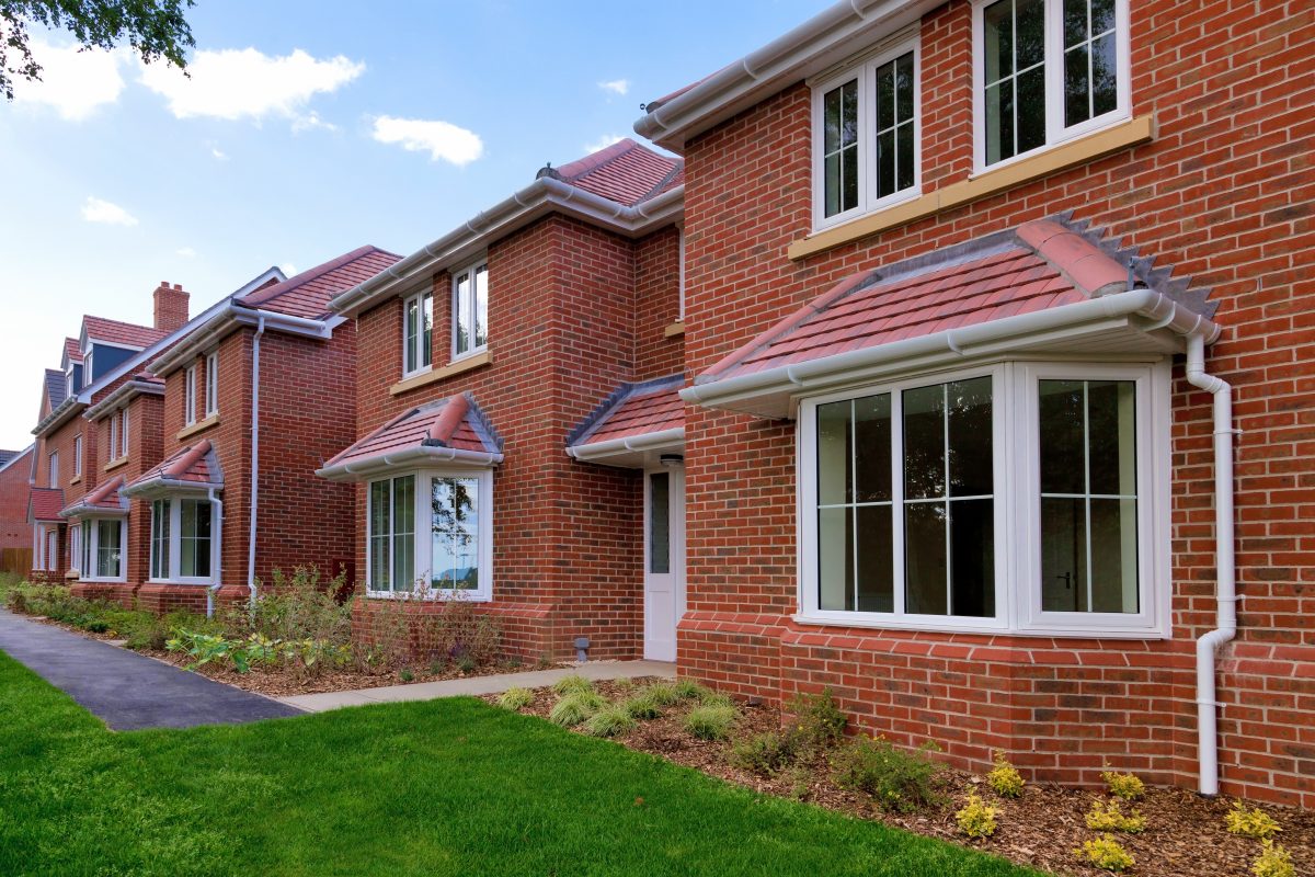 Photo of a row of brand new empty houses for sale on a housing development.